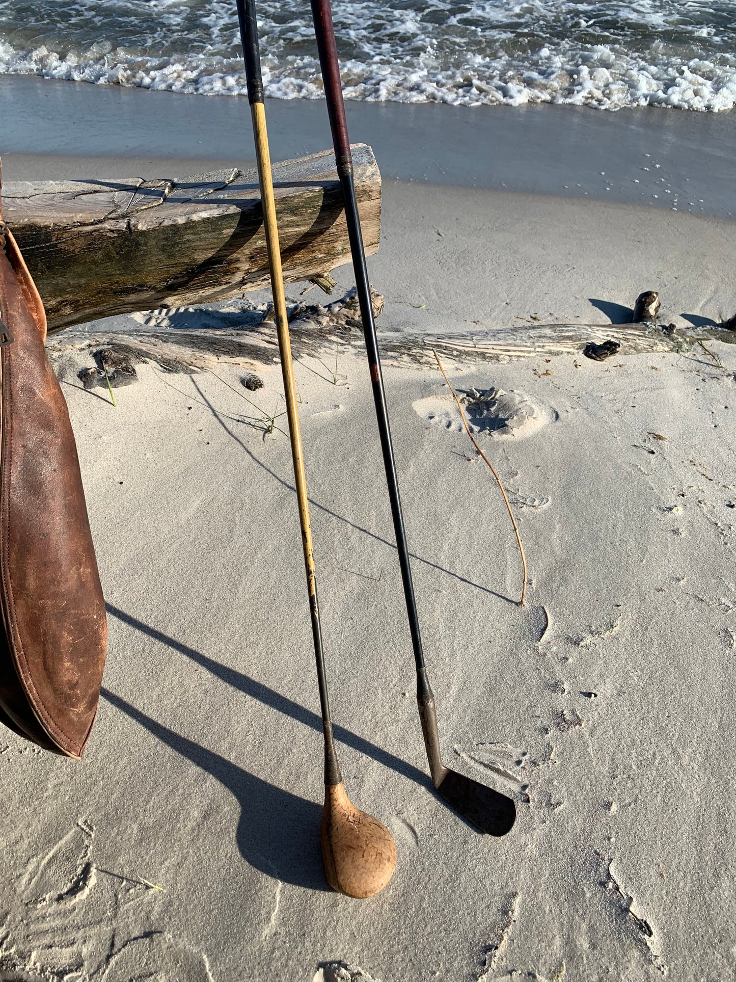 Gammel golfbag i læder med to gamle køller