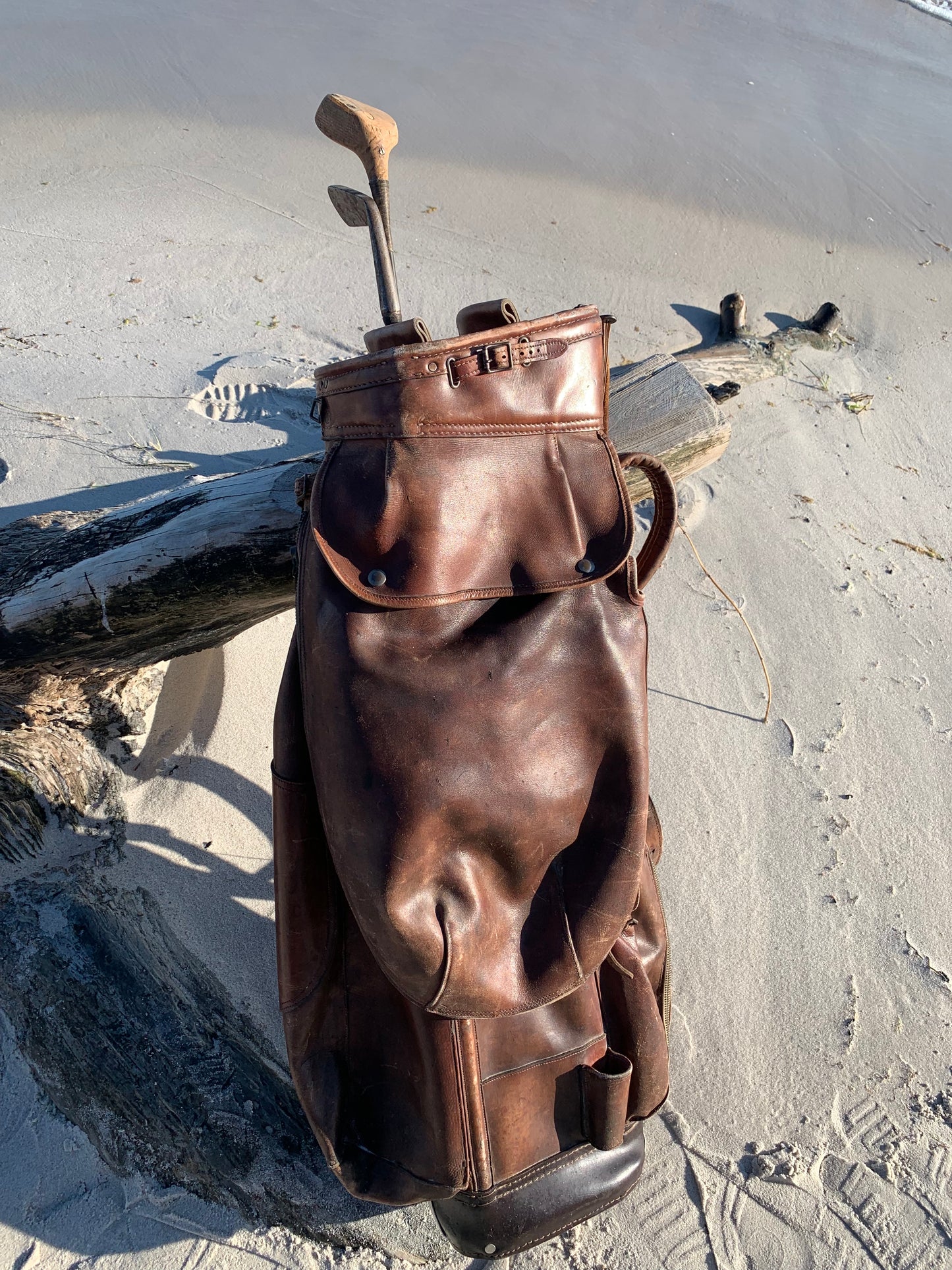 Gammel golfbag i læder med to gamle køller