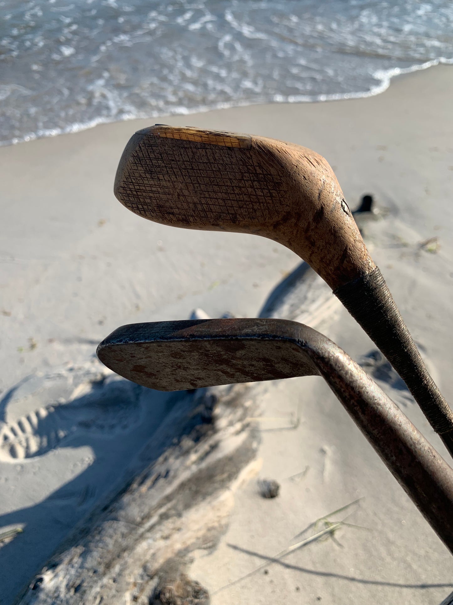Gammel golfbag i læder med to gamle køller