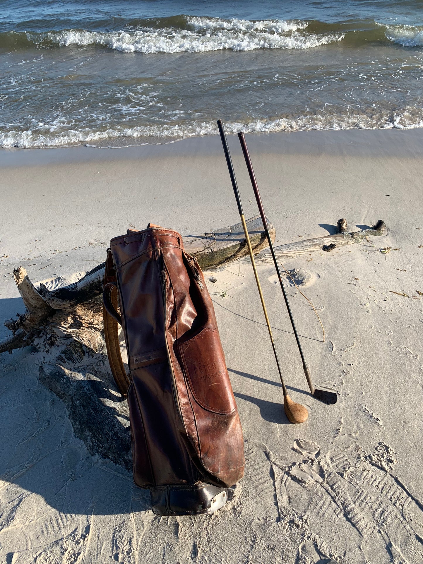 Gammel golfbag i læder med to gamle køller