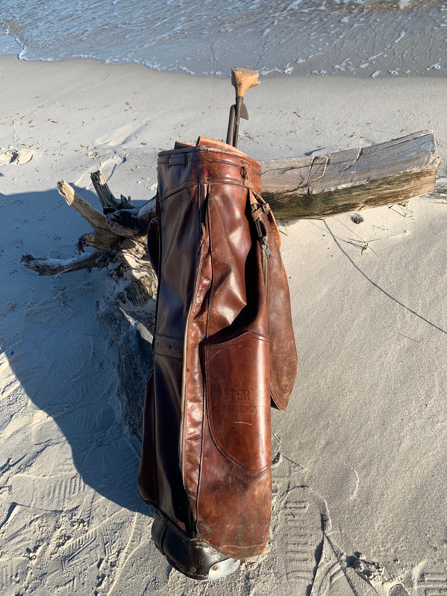 Gammel golfbag i læder med to gamle køller