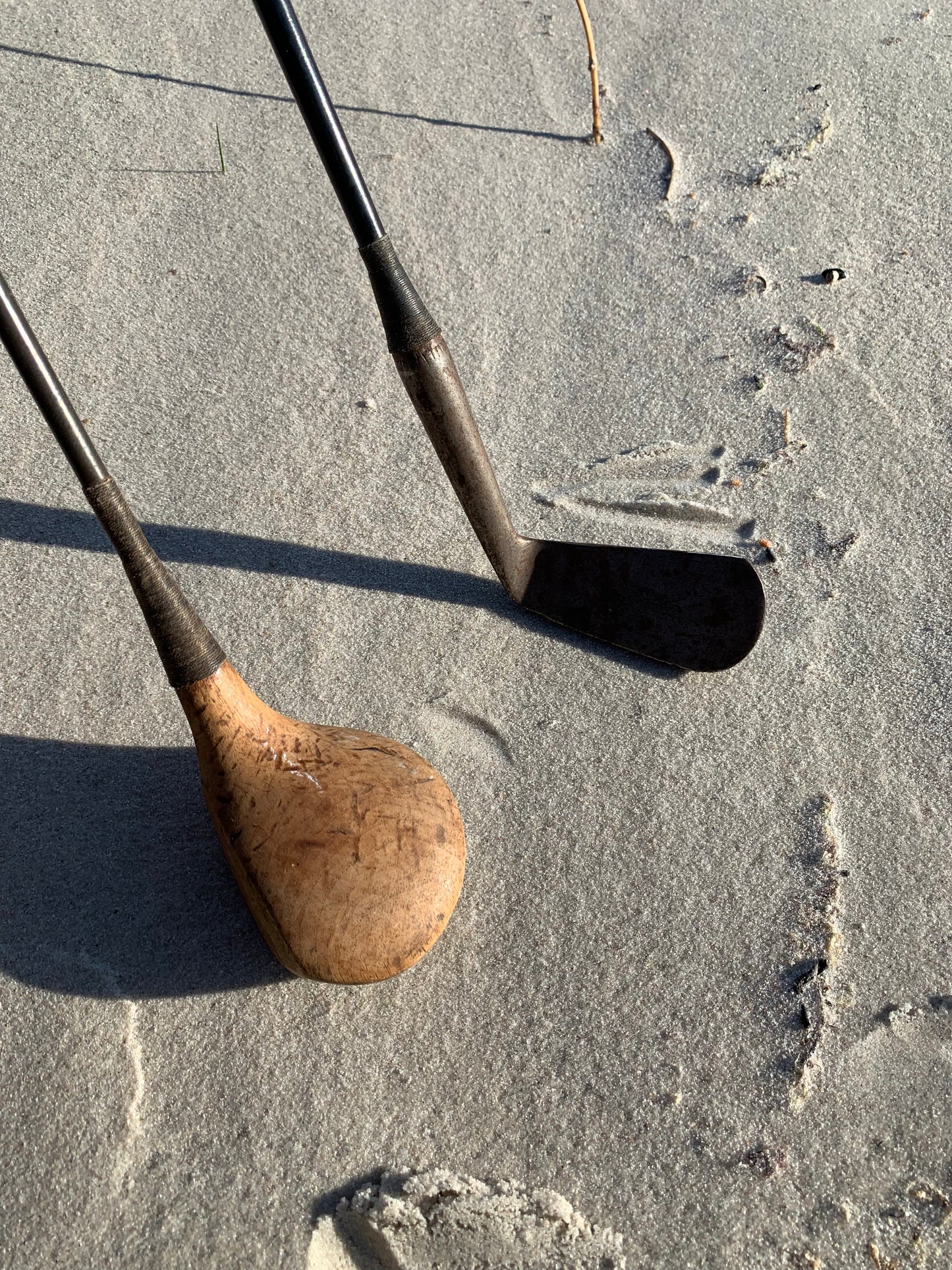 Gammel golfbag i læder med to gamle køller