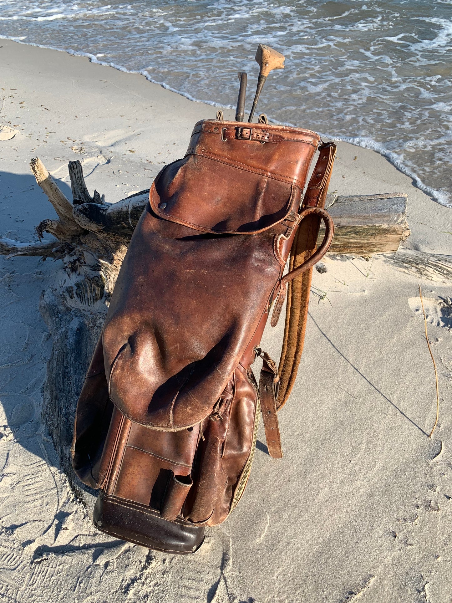 Gammel golfbag i læder med to gamle køller