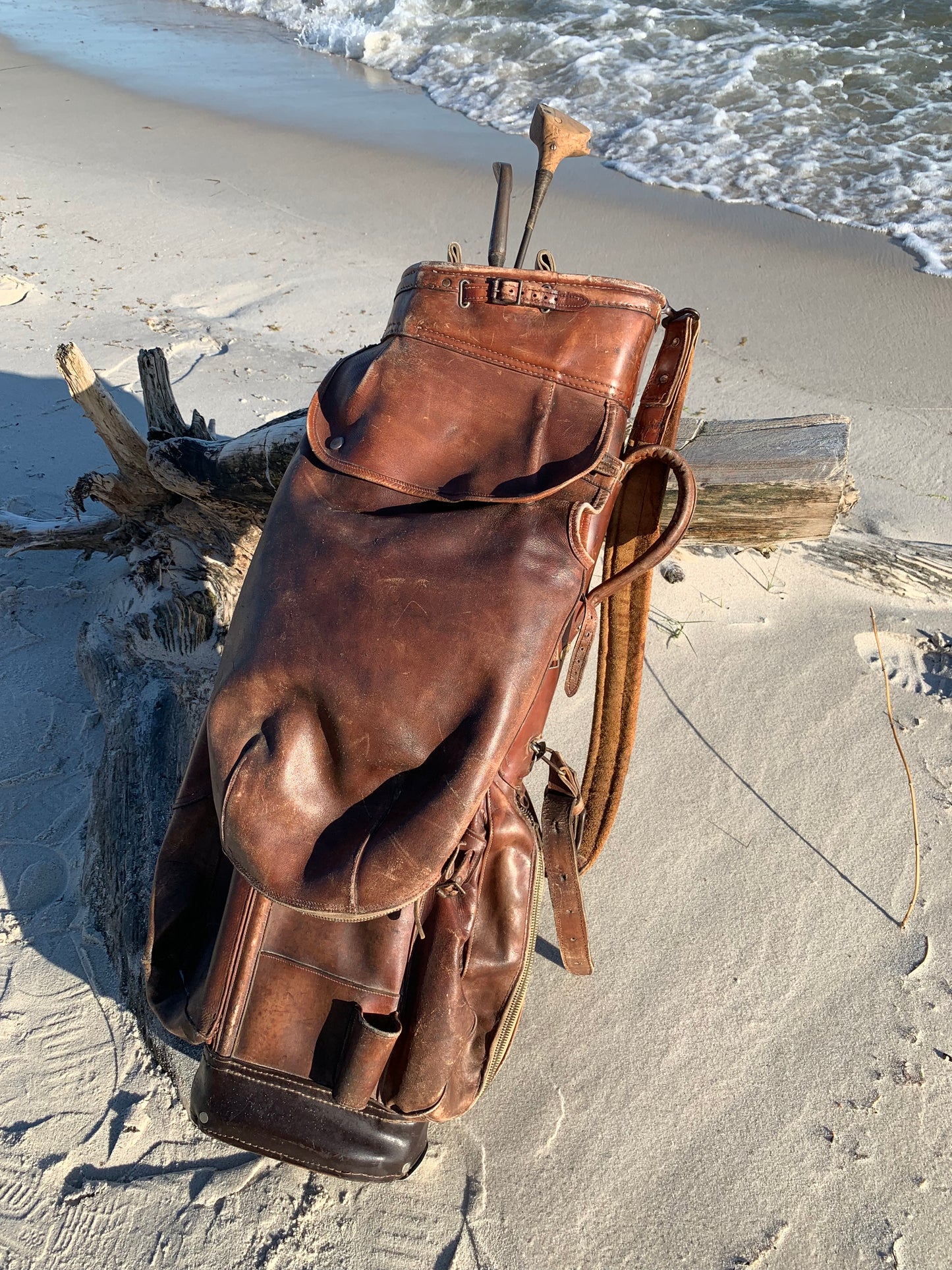 Gammel golfbag i læder med to gamle køller